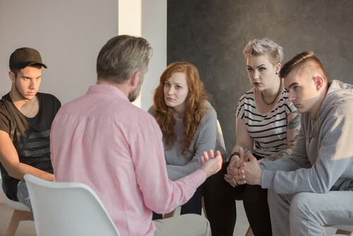 conseiller en addiction parlant avec un groupe de jeunes hommes et femmes